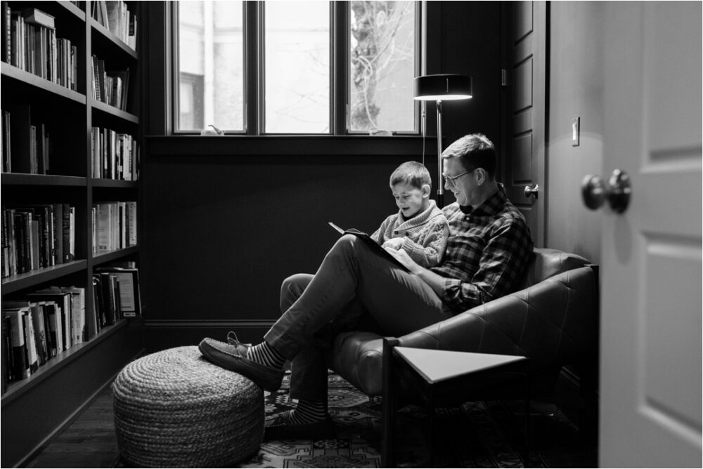 father reading to son in library